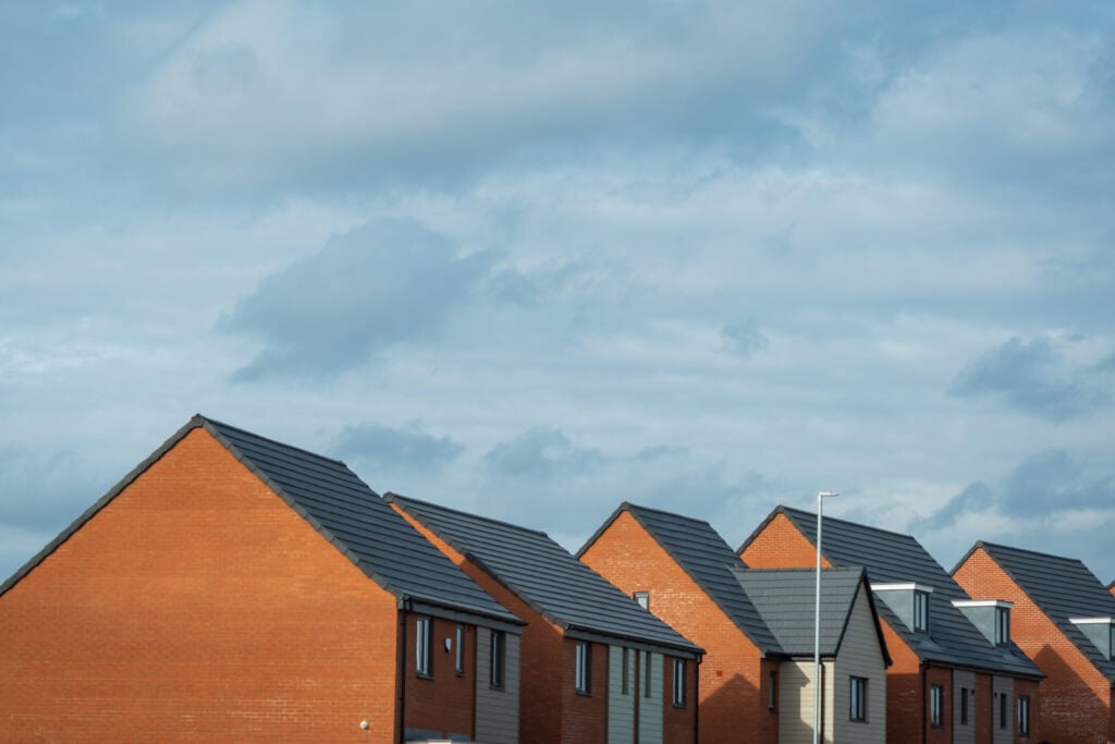 Residential houses with contemporary roofing in a peaceful residential area, featuring brick and modern grey tiles.