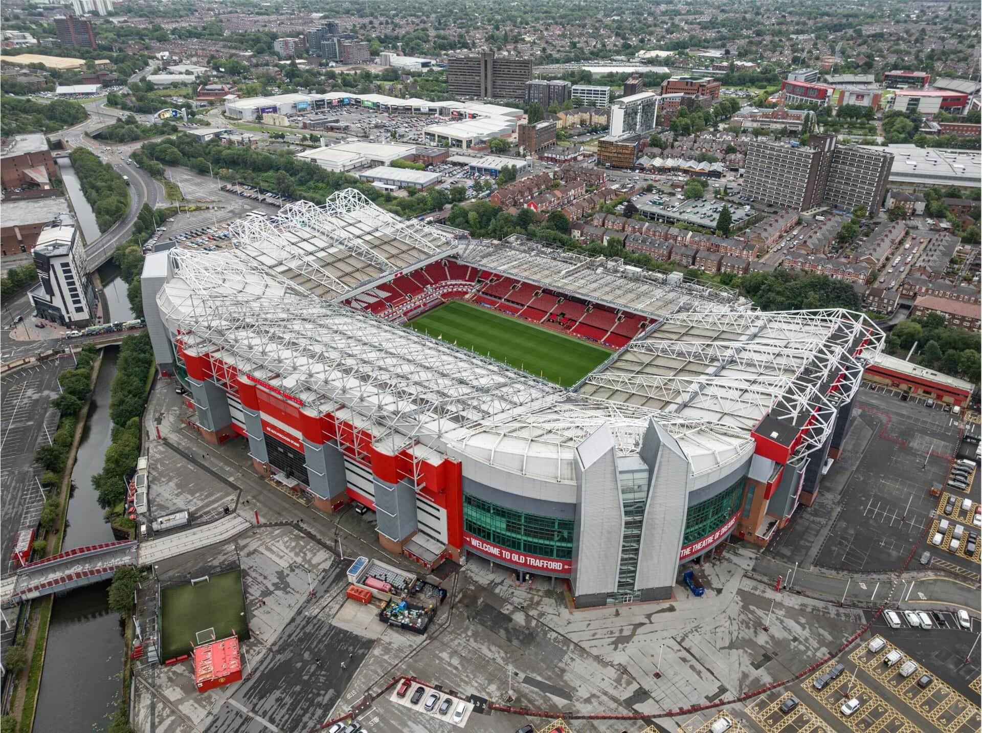Aerial view of Manchester United football stadium with surrounding cityscape.