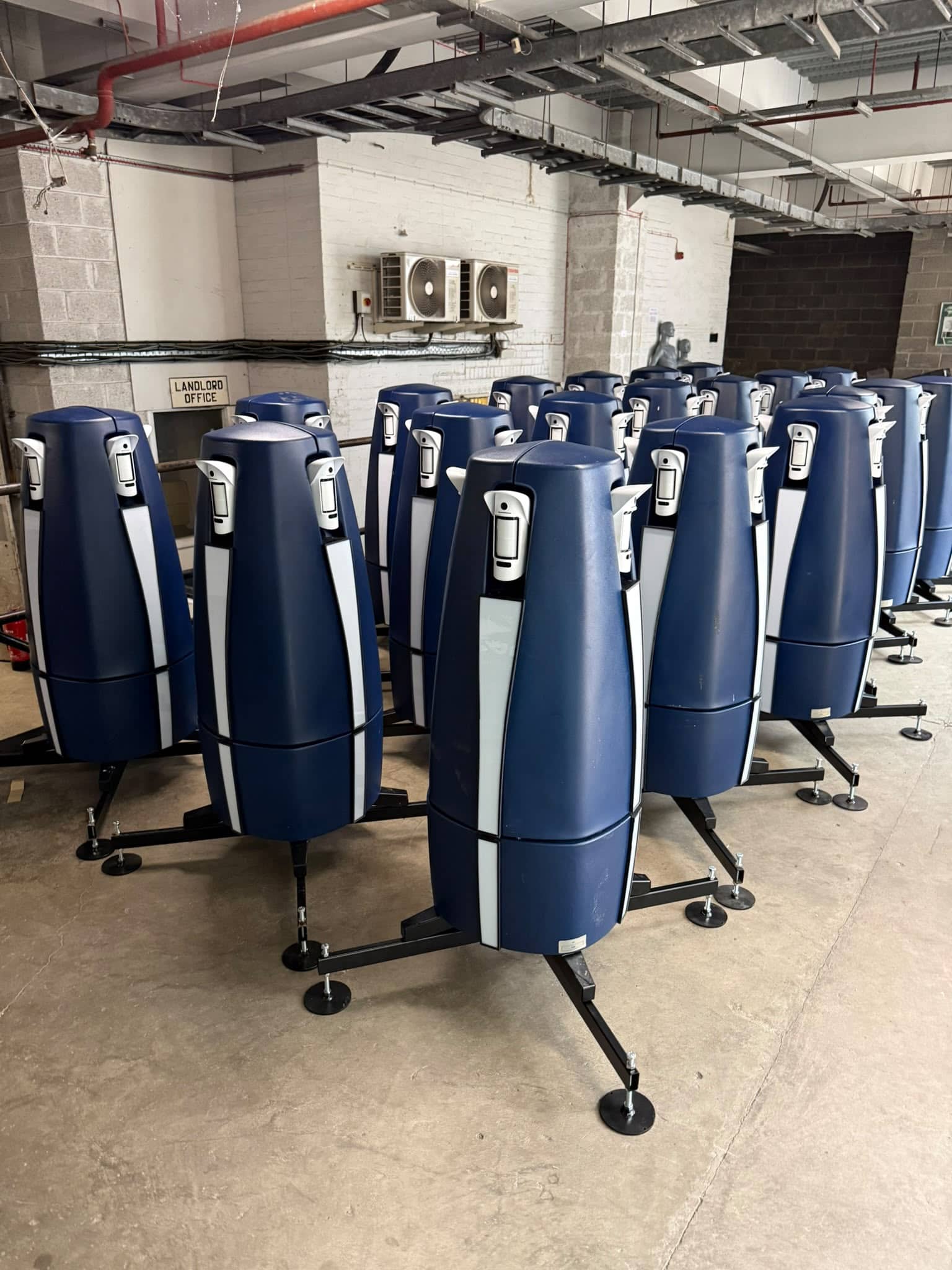 Multiple high-tech 3D printers in a manufacturing facility.